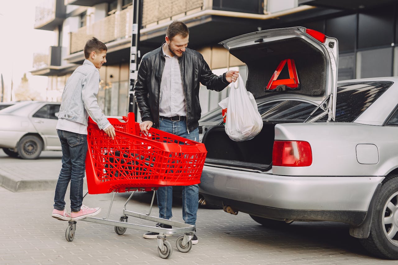 People putting groceries in the trunk of a car